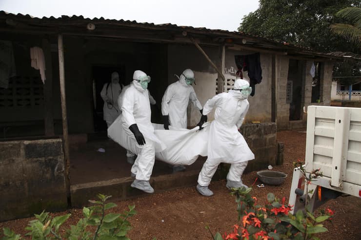 צוות רפואי עם גופה של אדם שמת מנגיף ה אבולה ליבריה 2014