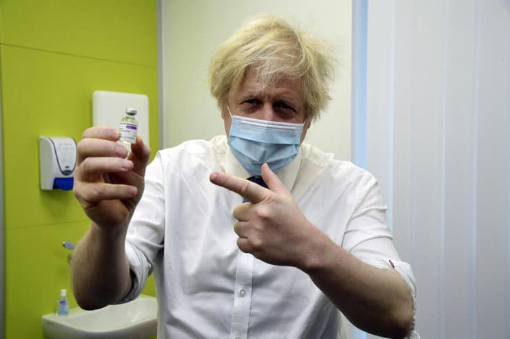 ראש ממשלת בריטניה בוריס ג'ונסון מחזיק חיסון ל קורונה