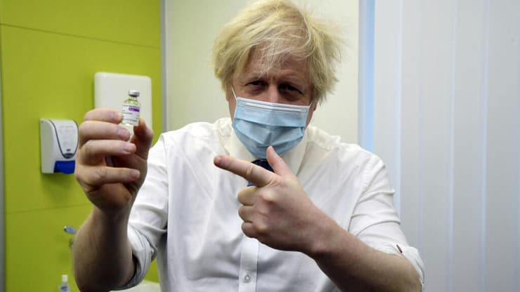 ראש ממשלת בריטניה בוריס ג'ונסון מחזיק חיסון ל קורונה