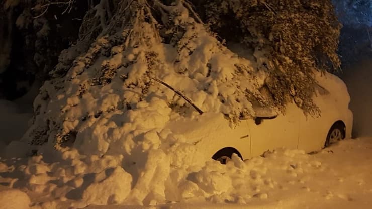 שלג נערם על רכב ב קיבוץ מרום גולן