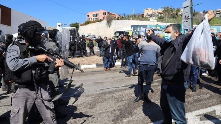 שוטרים מכוונים נשק למפגינים בהפגנה נגד האלימות באום אל פחם
