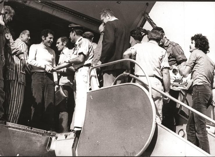 1973: מנחם עיני יורד מהמטוס שהחזיר את השבויים ומתקבל על ידי מפקד חיל האוויר, האלוף בני פלד