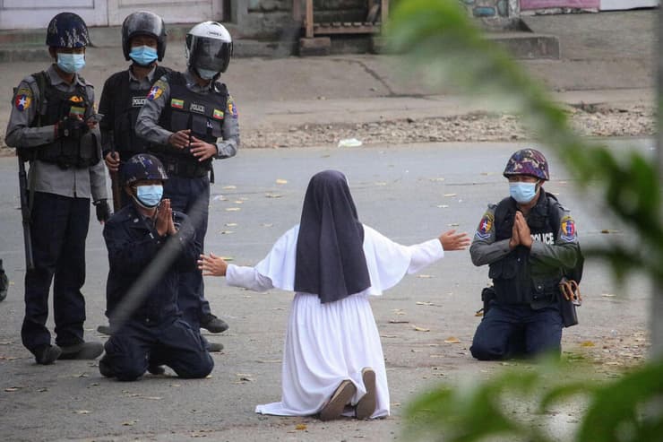מיאנמר נזירה מתחננת בפני שוטרים הפיכה צבאית הפגנה מפגינים בעיר מייטקינה