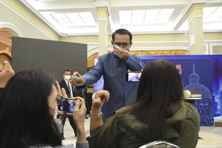 ראש ממשלת תאילנד פראיות צ'אן אוצ'ה מתיז חומר חיטוי על עיתונאים
