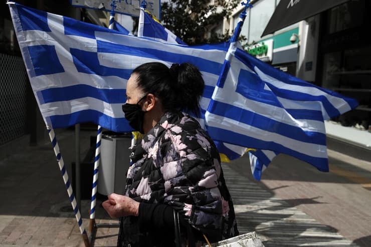 אישה במסכה באתונה. כמעט 10% קיבלו לפחות זריקה אחת   