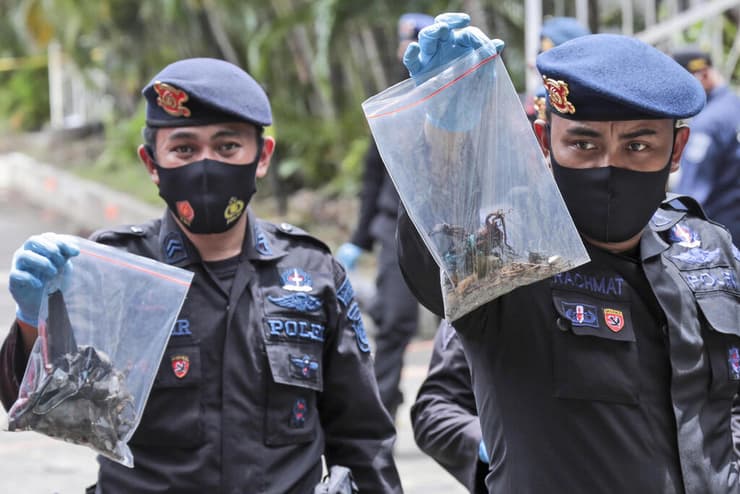 שוטרים עם ממצאים שנאספו בזירת הפיצוץ 