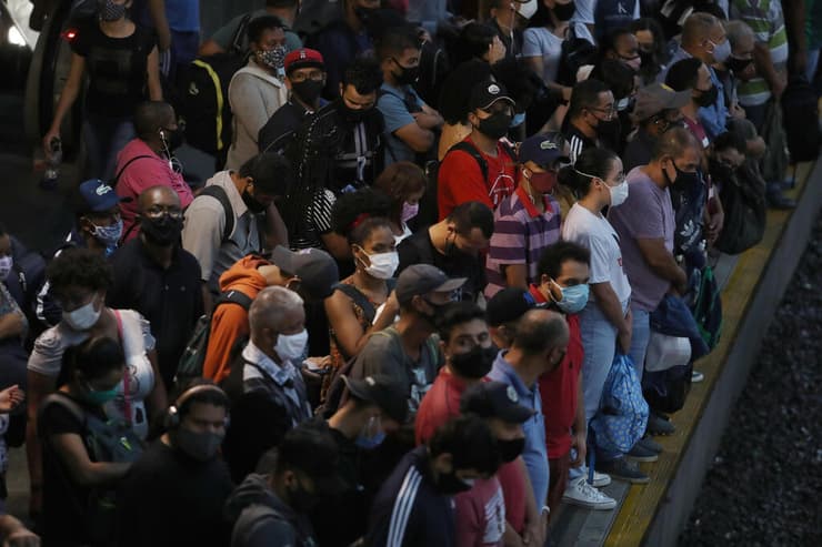 עומדים בצפיפות בתחנת רכבת בסאו פאולו. הרשויות המקומיות מתחילות להסיר הגבלות  