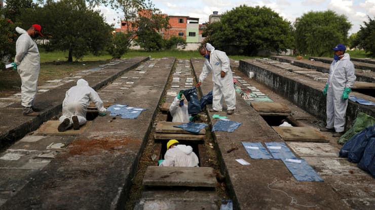 חופרים קברים לקורבנות הקורונה בסאו פאולו, ברזיל, בשבוע שעבר. "העולם עדיין סובל קשות מהווירוס"