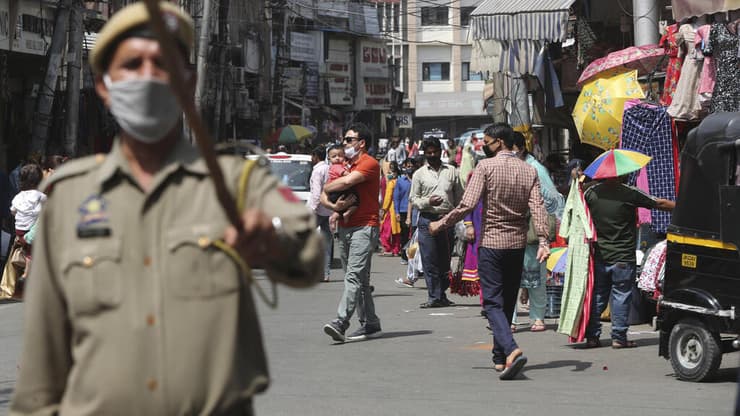 הודו קורונה שוטר אוכף עטיית מסכות ב שוק ב ג'אמו