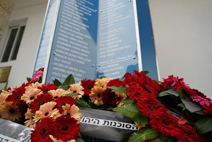זירי הפרחים אל מול האנדרטה עם שמות הנספים. 