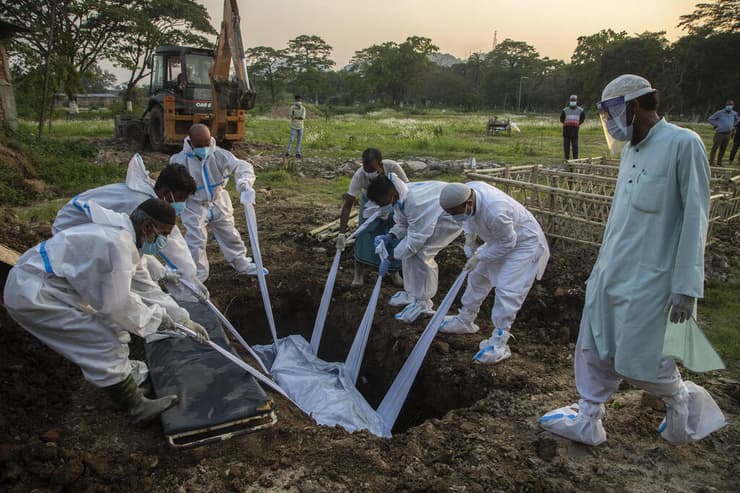 קוברים קבר חולה קורונה שמת בעיר גוואהטי ב הודו 