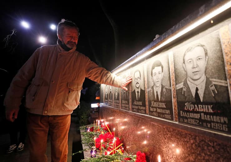 צוות תחנת הכוח ב צ'רנוביל מדליק נרות זיכרון לנספים בה באסון הגרעיני ב עיירה סלבוטיץ' שנבנתה עוברם
