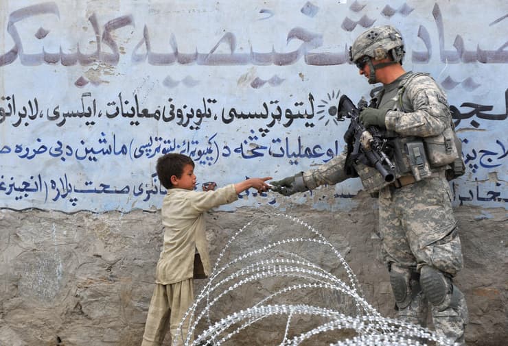 חייל אמריקני וילד אפגני בשנה שעברה. "יכלו להישאר עוד שנה"   