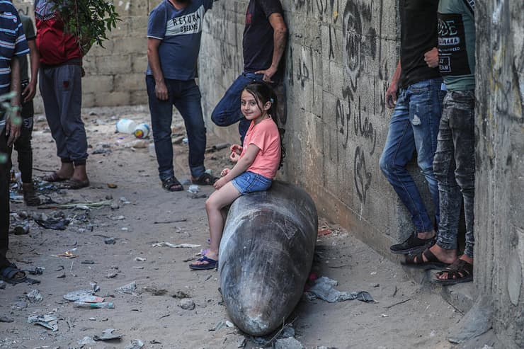 ילדים פלסטינים יושבים על טיל שלא התפוצץ