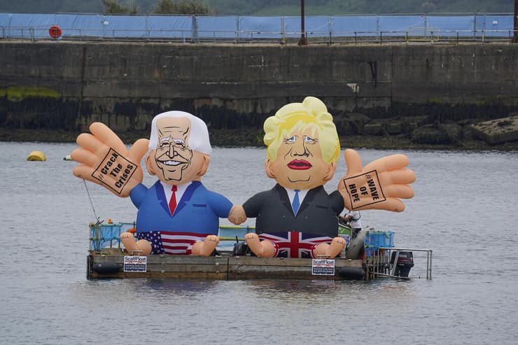 דמויותיהם של ביידן וג'ונסון צפות על המים מול אתר הוועידה 