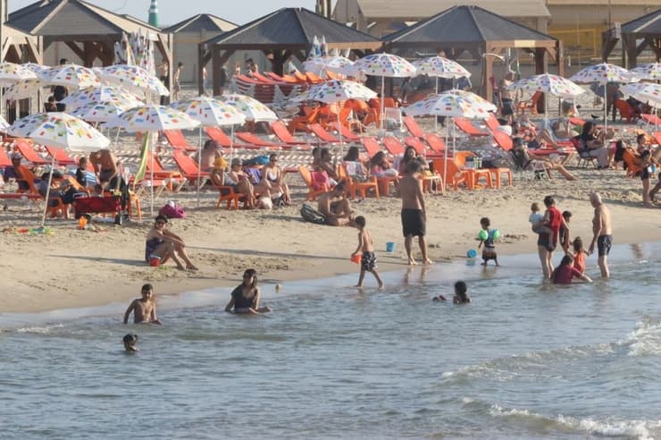 אנשים מבלים בחוף הים בתל אביב