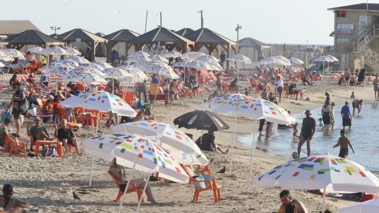אנשים מבלים בחוף הים בתל אביב