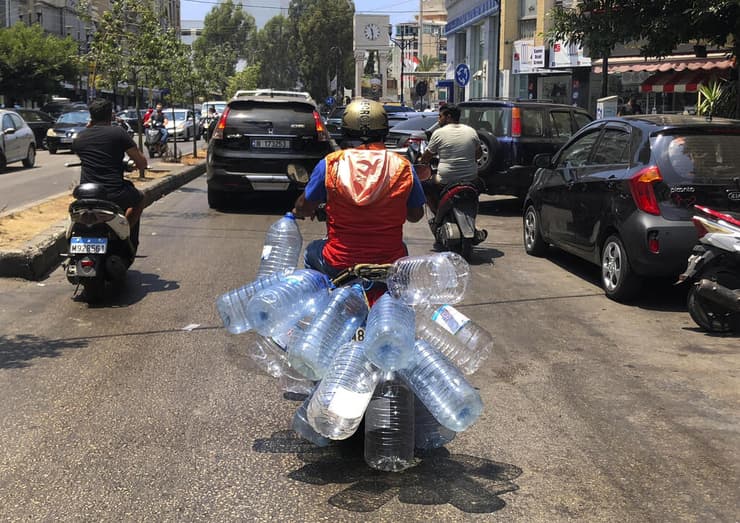 תושב לבנוני מצויד בבקבוקים גדולים, בדרכו - לנסות - למלא דלק 