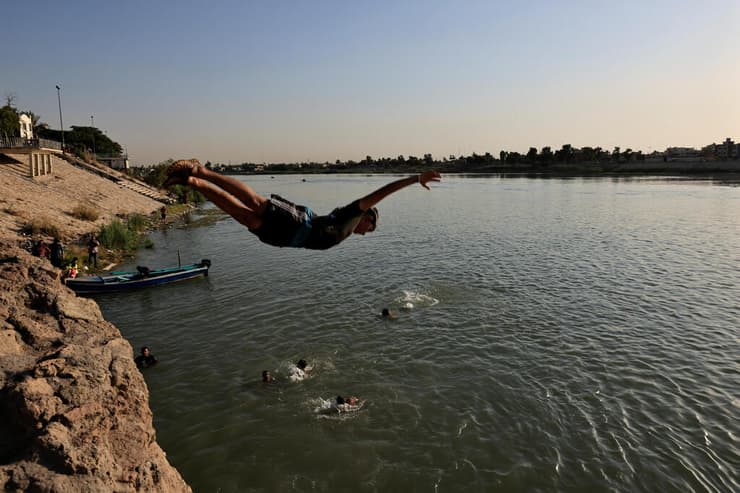 מתרחצים בנהר ה חידקל בגדד גל חום ב עיראק