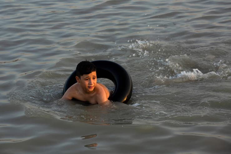 מתרחצים בנהר שט אל ערב בצרה דרום עיראק גל חום