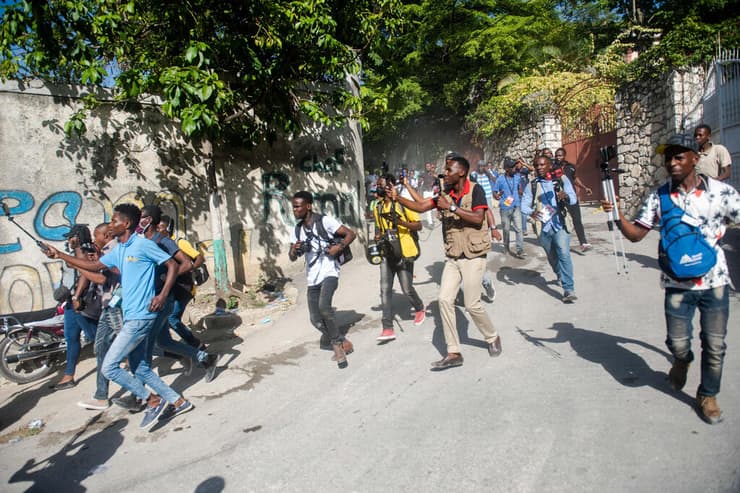 האיטי עיתונאים רצים אחרי אמבולנס המוביל את גופת הנשיא ז'ובנל מואיז ש נרצח