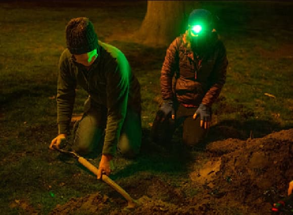 ביל יצר בנק זרעים מלאכותי המסתתר בקרקע. דיוויד לורי (שמאל) ומרג'ורי ובר (Weber) חופרים בחושך בחיפוש אחרי בקבוק זרעים