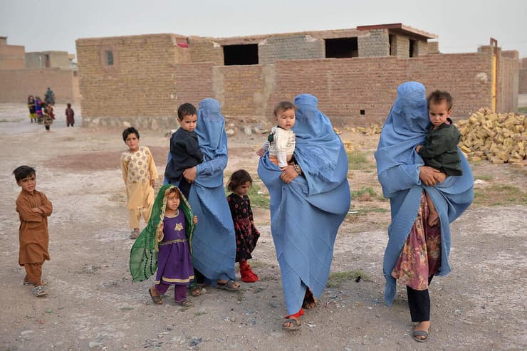 נשים ב בורקה בורחות מהעיר קלעה נאו, בירת מחוז בדגיס שבצפון-מערב אפגניסטן עקב קרבות עם הטליבאן טליבאן