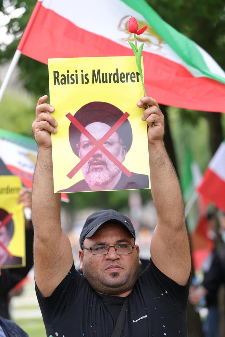 הפגנה ב ברלין גרמניה נגד השבעת נשיא איראן איברהים ראיסי שבה מוצגים תמונות איראנים שהוצאו להורג בשנות ה-80