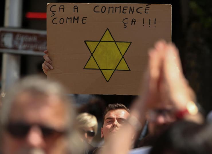 שלט עם טלאי צהוב הפגנה ב ריימס צרפת נגד חובת התחסנות לעובדי מגזרים מסוימים 