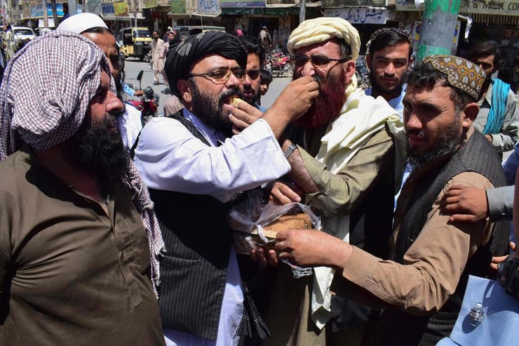 ממתקים לתוך הפה. תומכי הטליבאן בפקיסטן השכנה חוגגים את מסע הכיבושים שלו    