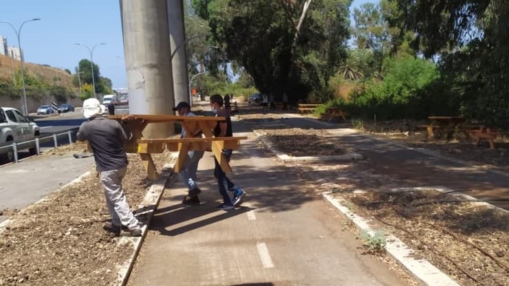 עובדי עיריית חיפה מוציאים את הספסלים סמוך לנחל סעדיה 