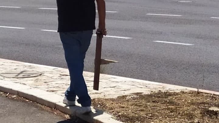 עובד עיריית חיפה מסיר את השלט שהכינו ילדים ותלו באתר המרכזי של הנחל