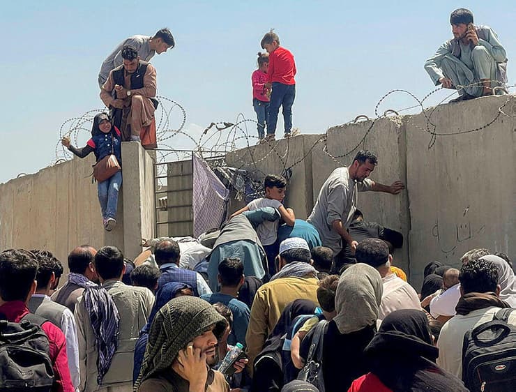 אפגניסטן קאבול אחרי השתלטות ה טליבאן גבר מכניס ילדה לתוך נמל התעופה קרזאי