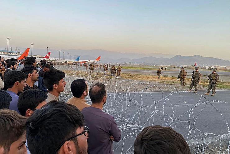 אפגניסטן קאבול נמל תעופה אפגנים צופים בעוד חיילים אמריקנים שומרים אחרי השתלטות ה טליבאן