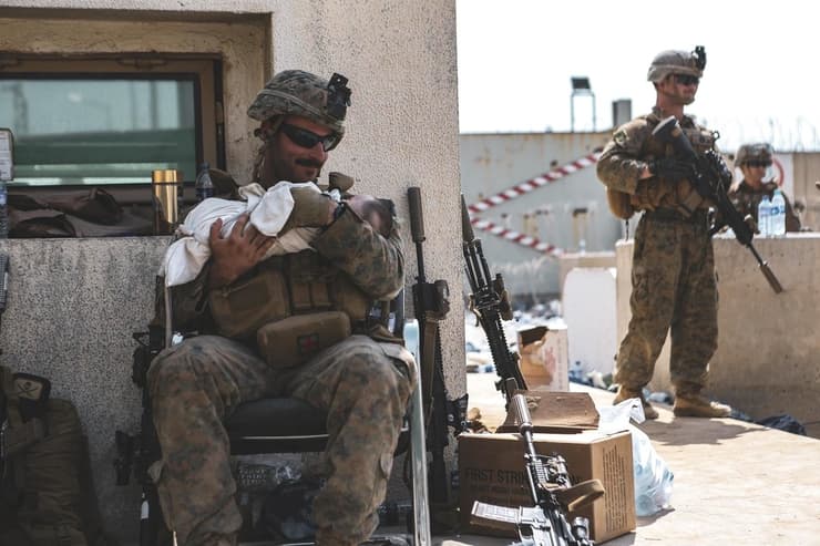 חיילים אמריקנים עם תינוקות שנמסרו לידיהם בנמל התעופה בקאבול 
