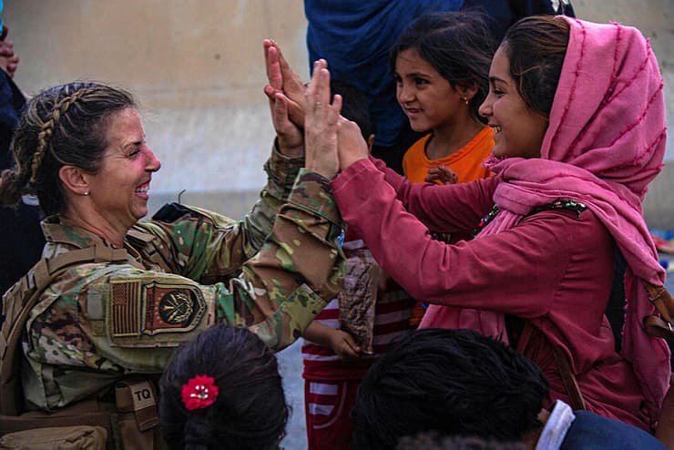 אפגניסטן טליבאן חיילת אמריקנית היי פייב עם ילדה אפגנית אחרי שעזרה לה למצוא את משפחתה בנמל התעופה