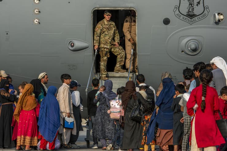 מפונים מ אפגניסטן עולים על טיסת המשך ל ארה"ב אחרי עצירה בבסיס של חיל האוויר האמריקני בקטאר 22 באוגוסט