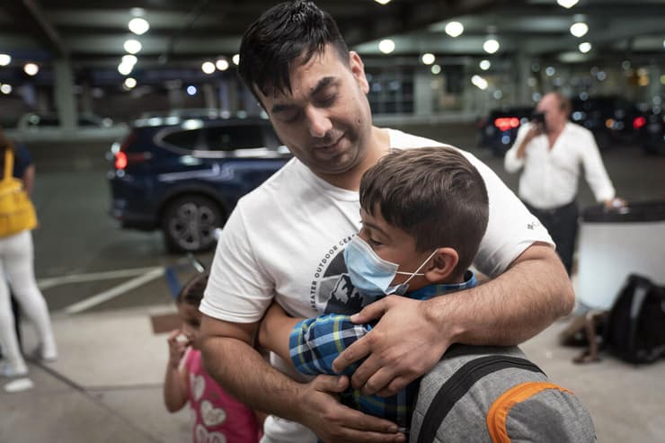 אדם שנתקע ב אפגניסטן מתאחד עם בנו הקטן לאחר טיסת חילוץ מ קאבול ב נמל תעופה ב מיניאפוליס ארה"ב