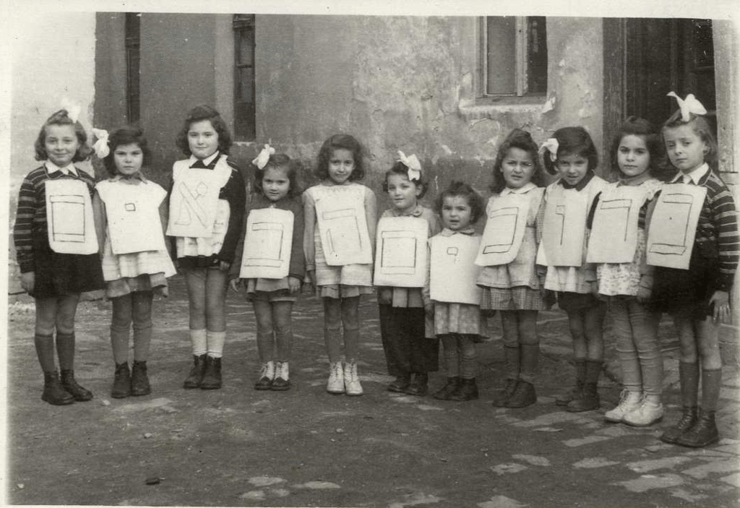 בית ספר לתלמוד תורה. תמונה קבוצתית של בנות עם אותיות נייר גדולות