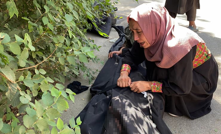 אישה מתאבלת ליד גופת קרוב משפחה שנרצח בפיגוע בקאבול