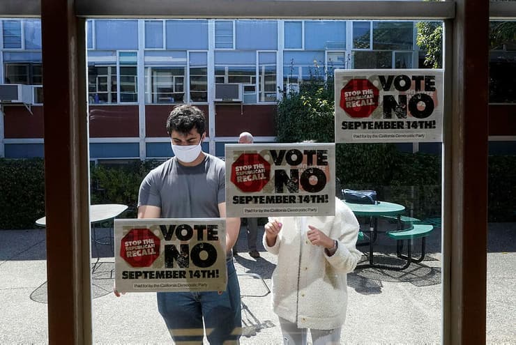 מתנדבים שתומכים ב גווין ניוסם תולים שלטים נגד הדחתו ב סן פרנסיסקו בחירות ל מושל קליפורניה ארה"ב