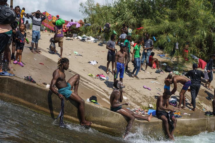 מהגר מהגרים מתרחצים ב נהר ריו גרנדה ליד מחנה מאולתר שהוקם מתחת ל גשר דל-ריו ב גבול ארה"ב טקסס לבין מקסיקו