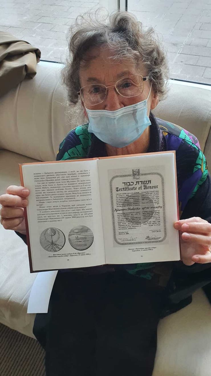 לריסה שולצקו עם הספר על אמה, אלכסנדרה, שהוכרה כחסידת אומות עולם אחרי שהצילה 25 ילדים יהודים מהטבח