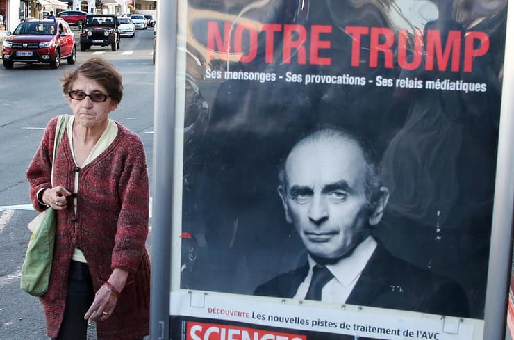 מפגינה שתומכת ב אריק זמור עם שלט "שבו כתוב הטראמפ שלנו" בעיר ביאריץ צרפת