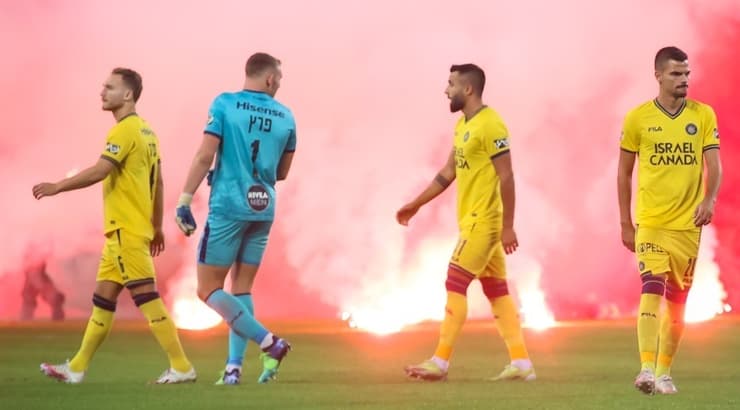 שחקני מכבי ת"א על רקע האבוקות