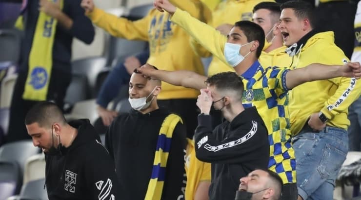 אוהדים ביציע עם מסיכות