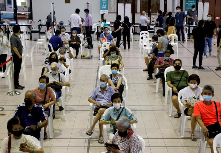 אנשים נחים לאחר קבלת החיסון במרכז חיסונים בסינגפור