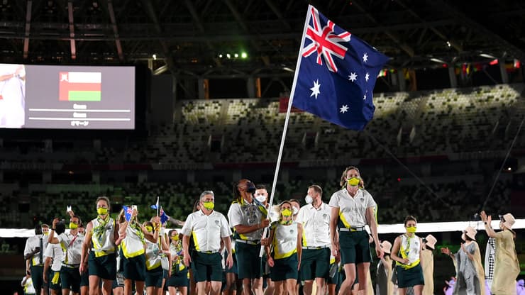 פאטי מילס נושא את הדגל של המשלחת האוסטרלית