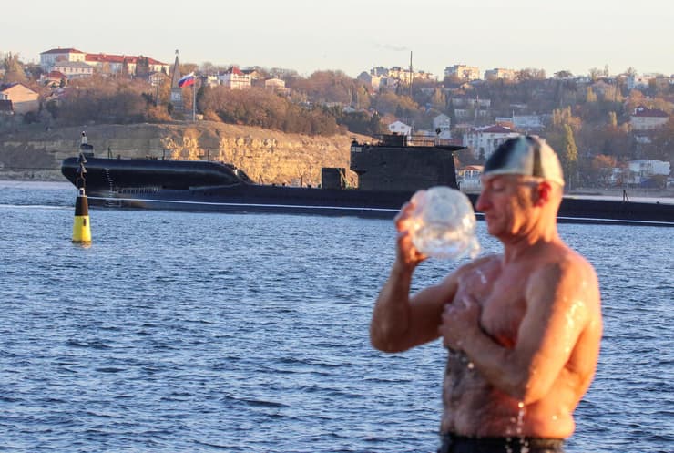 רוסיה גבר מתרחץ ב חצי האי קרים ברקע צוללת רוסית מתיחות עם אוקראינה