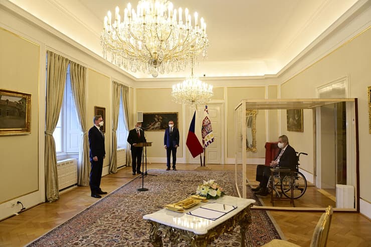מילוש זמאן נשיא צ'כיה בתא זכוכית משביע לתפקיד ראש הממשלה את פטר פיאלה